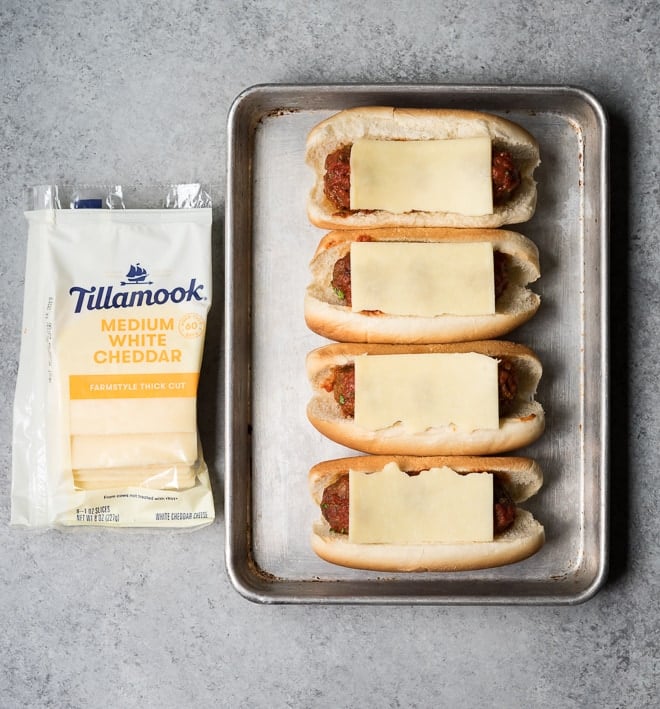 4 meatball subs with unmelted cheese on a sheet pan