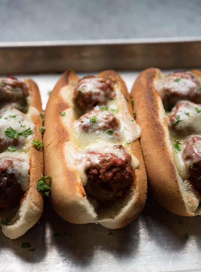 close up shot of a meatball sub with melted cheese on a toasted bun