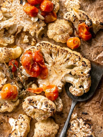 Cauliflower Steaks with Tomato Garlic Confit - roasted cauliflower steaks on sheet pan with tomato confit and spatula