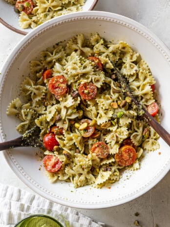 pasta salad in a bowl with serving utensils