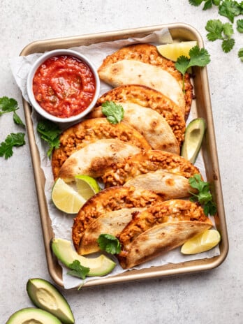 crispy tacos on a sheet pan with salsa