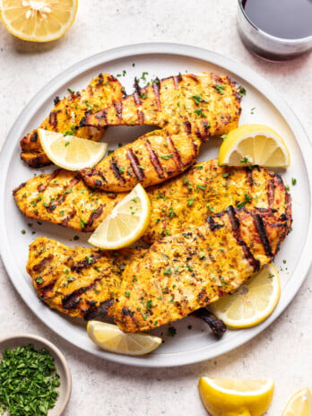 grilled chicken on a plate with lemon slices
