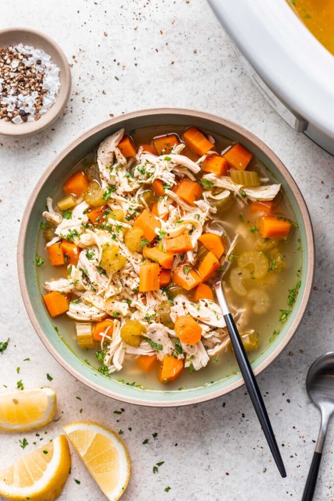 chicken noodle soup with carrots and celery and a spoon