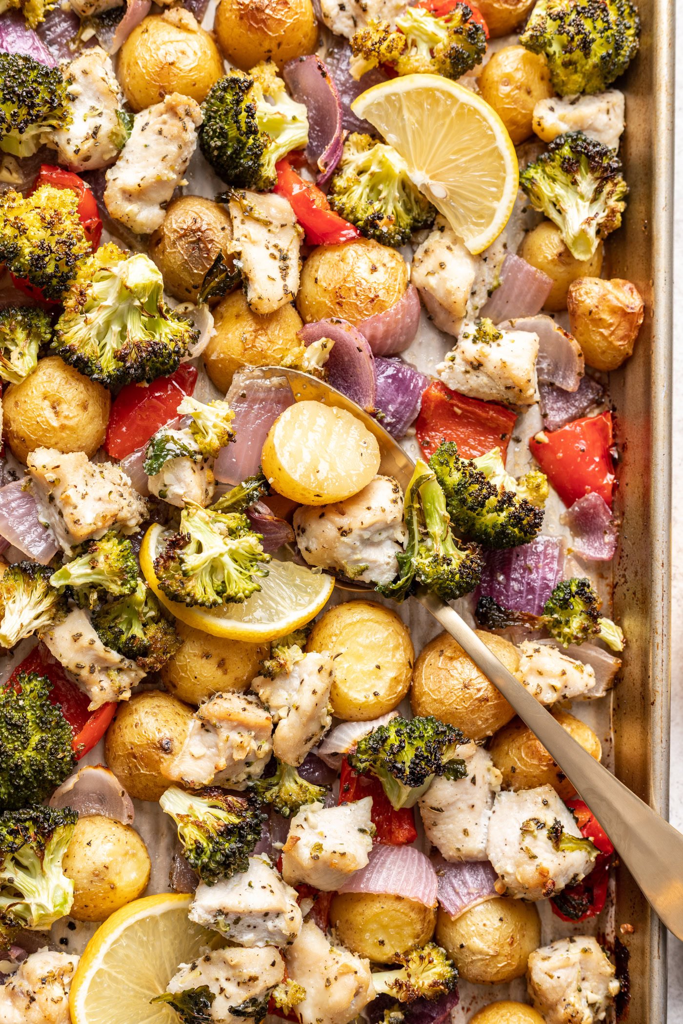 chicken pieces and veggies on a sheet pan