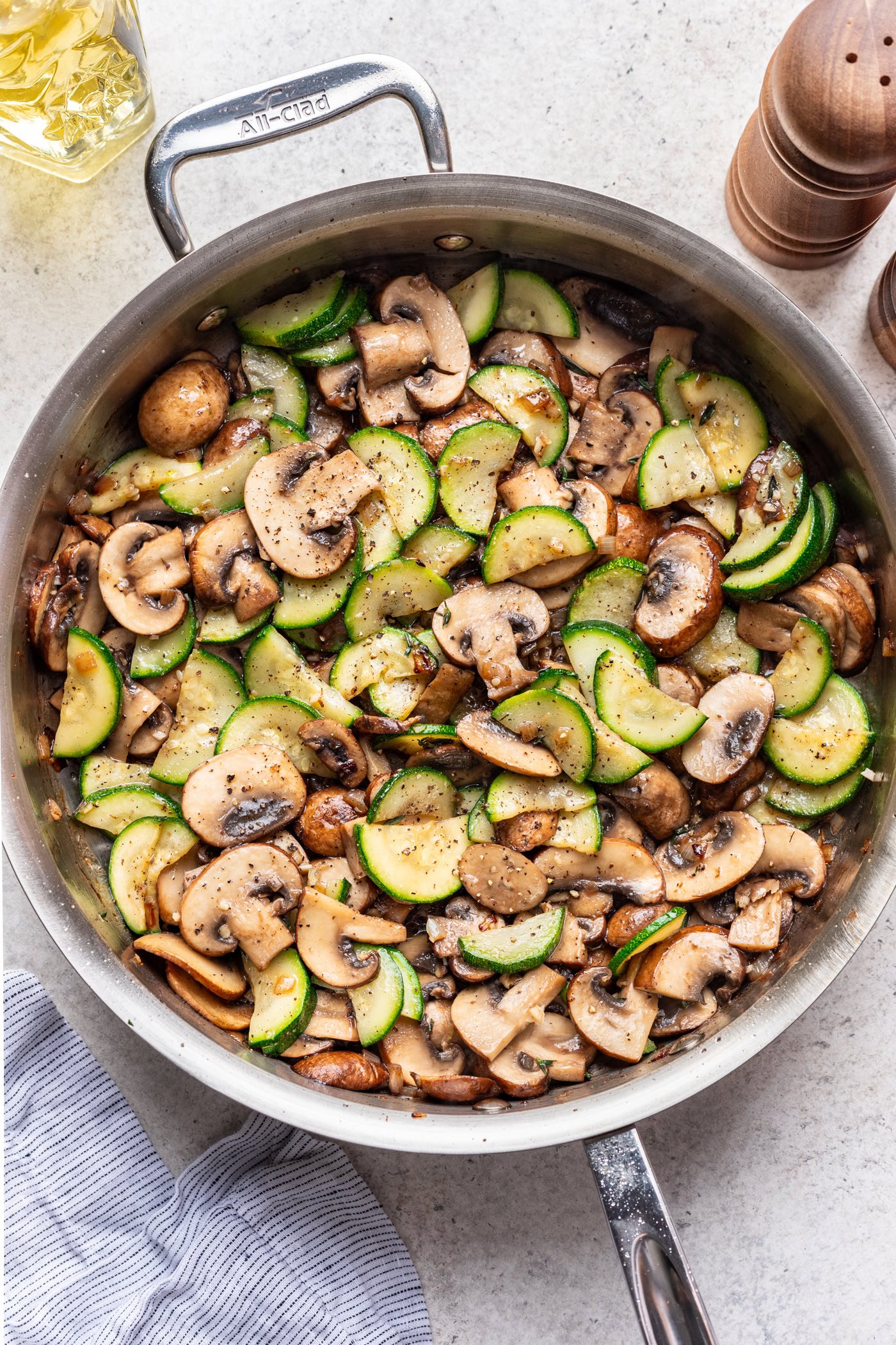 large skillet with sautéed zucchini and mushrooms