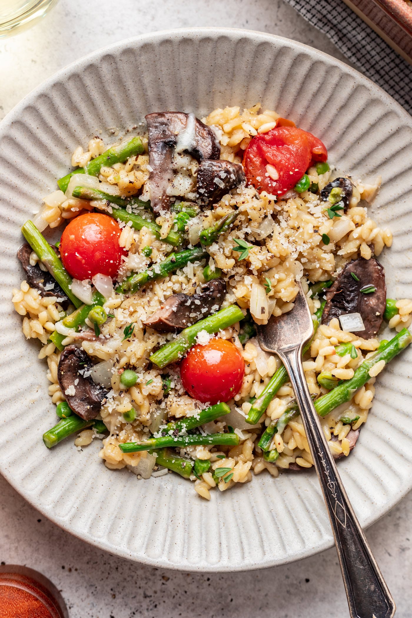 baked orzo and veggies in a bowl with a fork