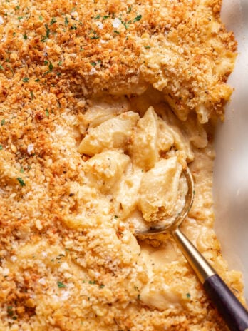 up close shot of a serving spoon in a dish of macaroni and cheese