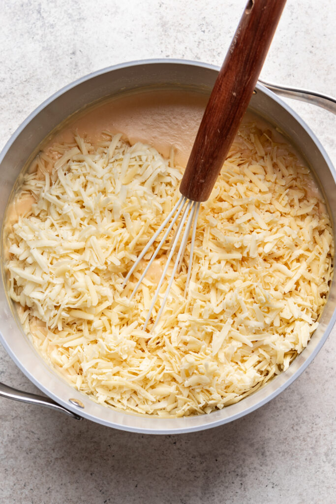 shredded cheese in a pot with roux