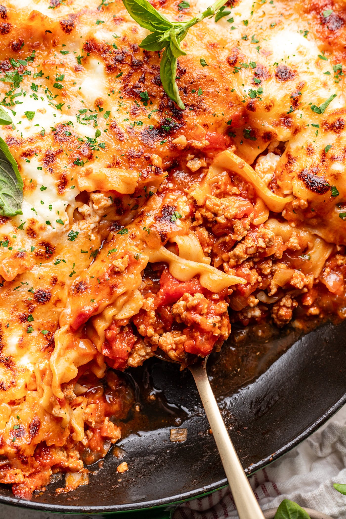 scooping lasagna out of a skillet