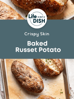 A tray of crispy, baked russet potatoes topped with chopped chives, some split open to show fluffy insides. The text reads: Life is But a Dish. Crispy Skin Baked Russet Potato.