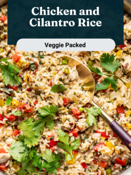 A pan filled with chicken and cilantro rice mixed with colorful vegetables, garnished with fresh cilantro, and a serving spoon. Text overlay reads: Chicken and Cilantro Rice, Veggie Packed.